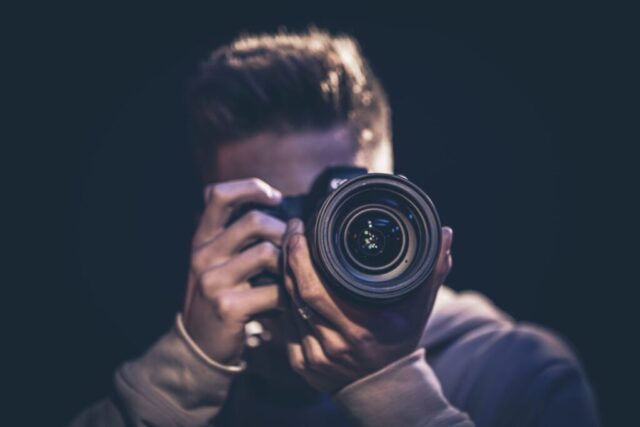 a-man-photographer-with-a-camera-takes-a-photo-in-the-dark--e1648018650879.jpg