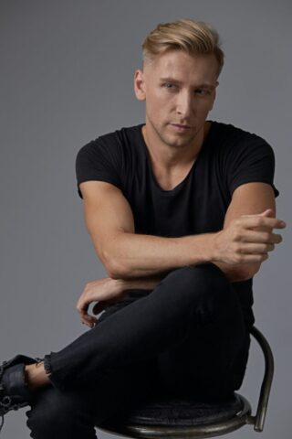 portrait-young-stylish-man-model-sitting-leg-over-leg-thoughtful-e1647854062325.jpg